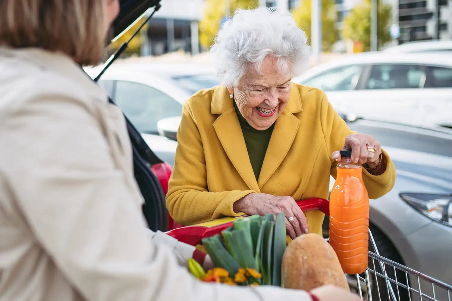 mature granddaughter helping grandmother load groceries car senior woman shopping shopping center copy